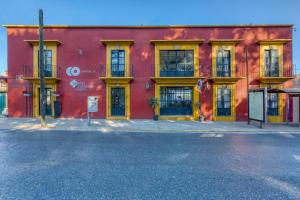 a red building with yellow doors on a street at Capital O Parador Crespo Hotel, Oaxaca in Oaxaca City