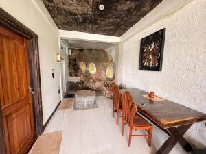 a dining room with a wooden table and chairs at Elizabeth Water Gate in Teldeniya
