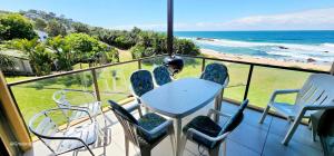 a balcony with a table and chairs and the ocean at Serene Shores - Sleeps 8 in Margate