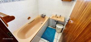 a bathroom with a tub and a sink and a toilet at Serene Shores - Sleeps 8 in Margate