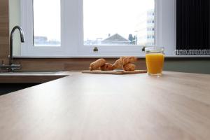 a table with a glass of orange juice and some pastries at Modern Comfort 4 Bedrooms and Great Location in Cardiff +73 photos