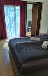 a bedroom with a bed and a large mirror at Gutenberg Villa in Balatonalmádi
