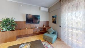 a living room with a tv and a chair at Coastal Nest Apartments in Durrës