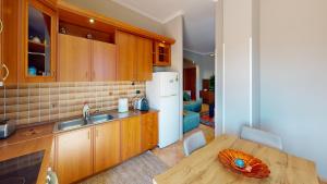 a kitchen with a table and a white refrigerator at Coastal Nest Apartments in Durrës