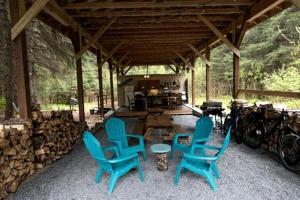 a pavilion with blue chairs and a table and bikes at Alaskan Yurt Glamping, Perfect for a Couples Getaway in Seward