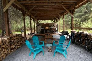 a group of blue chairs and a table in a pavilion at Alaskan Yurt Glamping, Perfect for a Couples Getaway in Seward