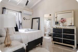 a bedroom with a large bed and a mirror at Barefoot Bliss Short Term Rental with pool in Colbeck Manor in Claremont +15 photos
