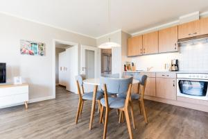 a kitchen and dining room with a table and chairs at Fehmarnstrand 77 Whg 2 in Staberdorf