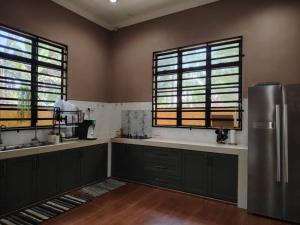 a kitchen with a stainless steel refrigerator and two windows at Wanda Homestay Terengganu in Kampong Wakaf Tengah +27 photos