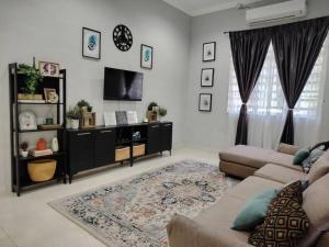 a living room with a couch and a tv at Wanda Homestay Terengganu in Kampong Wakaf Tengah