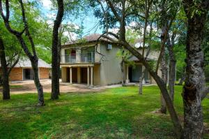 a house with trees in front of it at Mshengu Kruger Lodge in Marloth Park