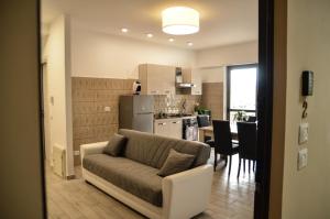 Una sala de estar con un sofá y una cocina. en Appartamento Siderno sul mare bilocale, en Siderno Marina