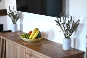 a bowl of fruit on top of a wooden counter at Sobe Plantić in Kostanjevec Riječki