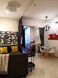 een woonkamer met een bank en een tafel bij The Shore Artsy Studio Kota Kinabalu in Kota Kinabalu