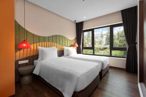 two white beds in a room with windows at Lestar Hotel Sapa in Sa Pa +31 photos