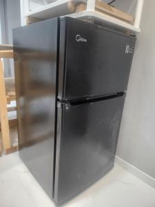 a black refrigerator in the corner of a kitchen at Sweet Home in Seoul
