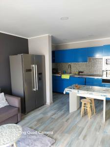 a kitchen with blue cabinets and a stainless steel refrigerator at marina in Acantilado de los Gigantes