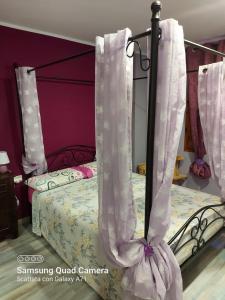 a bedroom with a bed with white curtains on it at marina in Acantilado de los Gigantes