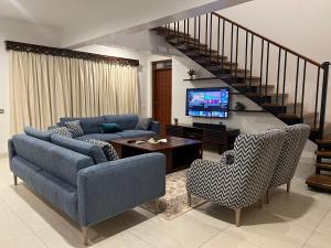 a living room with two couches and a tv at Lihanda Villa in Kilifi