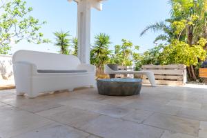 Un patio con dos sillas blancas y una mesa. en Villa Bianca Marina, en Villanova di Ostuni 32 fotos más