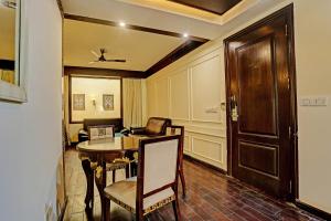 a room with a table and a chair and a door at Super Townhouse The Royce New Friends Colony in New Delhi