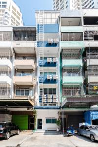 an apartment building with balconies and cars parked in a parking lot at Petchaburi22 Apartments next to Platinum mall in Bangkok