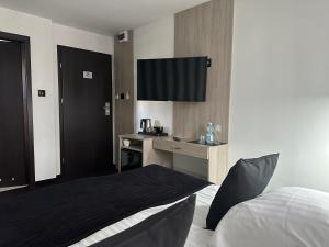 Pokój hotelowy z łóżkiem i biurkiem z telewizorem w obiekcie Willa Sandomierska w mieście Sandomierz