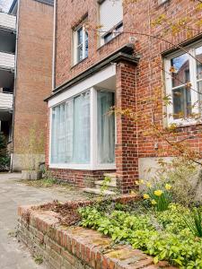 a brick house with a garden in front of it at City-Apartment Kreuzviertel-Lädchen-60 qm in Münster