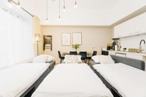 two beds in a room with a table and chairs at City-Apartment Kreuzviertel-Lädchen-60 qm in Münster