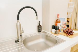 a kitchen sink with a faucet and wine bottles at City-Apartment Kreuzviertel-Lädchen-60 qm in Münster +42 photos