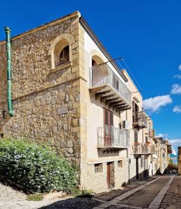 a stone building with balconies on the side of it at Casa Al Plumbago in Termini Imerese