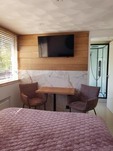 a bedroom with a bed and a table and a television at Dishoek in Dishoek