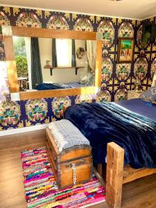 a bedroom with a bed with a trunk and a mirror at Golspie House, Margate in Margate