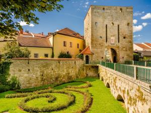 an old stone wall with a garden and a castle at Köpplmühle Apartment im Herzen von Freistadt in Freistadt