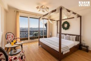 a bedroom with a canopy bed and a balcony at StayVista at The Apricot with Heater & BBQ in Mashobra