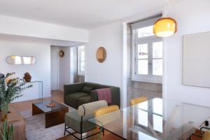 a living room with a green couch and a glass table at Riverfront Stylish Apartment - waterfront 2BR in Viana do Castelo +13 photos