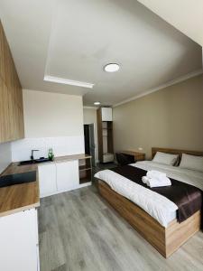 a bedroom with a large bed and a kitchen at Уют студия in Astana +22 photos