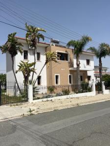 a house with palm trees in front of a fence at Tranquil paradise in Larnaca