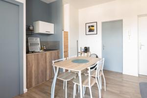 a kitchen and dining room with a wooden table and chairs at TERRASSE DU MAINE - Centre ville - Wifi in Saint-Nazaire