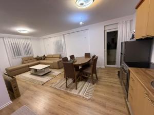 a living room with a table and a couch at Apartament me qera Gjilan,te sheshi in Gjilan