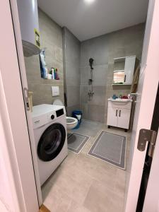 a small bathroom with a washing machine in it at Apartament me qera Gjilan,te sheshi in Gjilan +7 photos