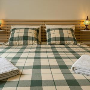 a bedroom with two pillows and a checkered floor at Maison Provençale - Piscine & Terrain de Pétanque in Grillon