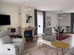 a living room with a couch and chairs and a fireplace at Maison Provençale - Piscine & Terrain de Pétanque in Grillon