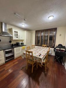 a kitchen with a table and chairs and a kitchen with a stove at Alin Duna in London