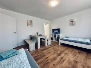 a room with two beds and a desk and a television at FeWo Euregio III Zentral & Klinik-Nähe in Nordhorn