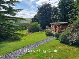 a log cabin in the middle of a grass field at Lake District Log Cabins in Broughton in Furness +10 photos