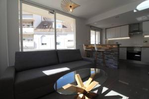 a living room with a black couch and a glass table at Apartamento Ama Altea in Altea