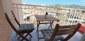 two chairs and a table on a balcony with a view at Apartamento en Playa Honda - La Manga in Cartagena