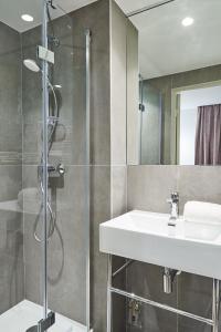 a bathroom with a sink and a shower at Hotel Cervantes by Happyculture in Paris