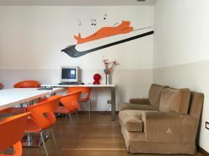 uma sala de estar com um sofá e uma mesa com cadeiras laranja em L'Archetto em Cremona